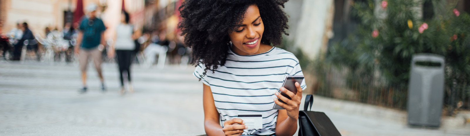 a woman in a striped shirt looking at her phone